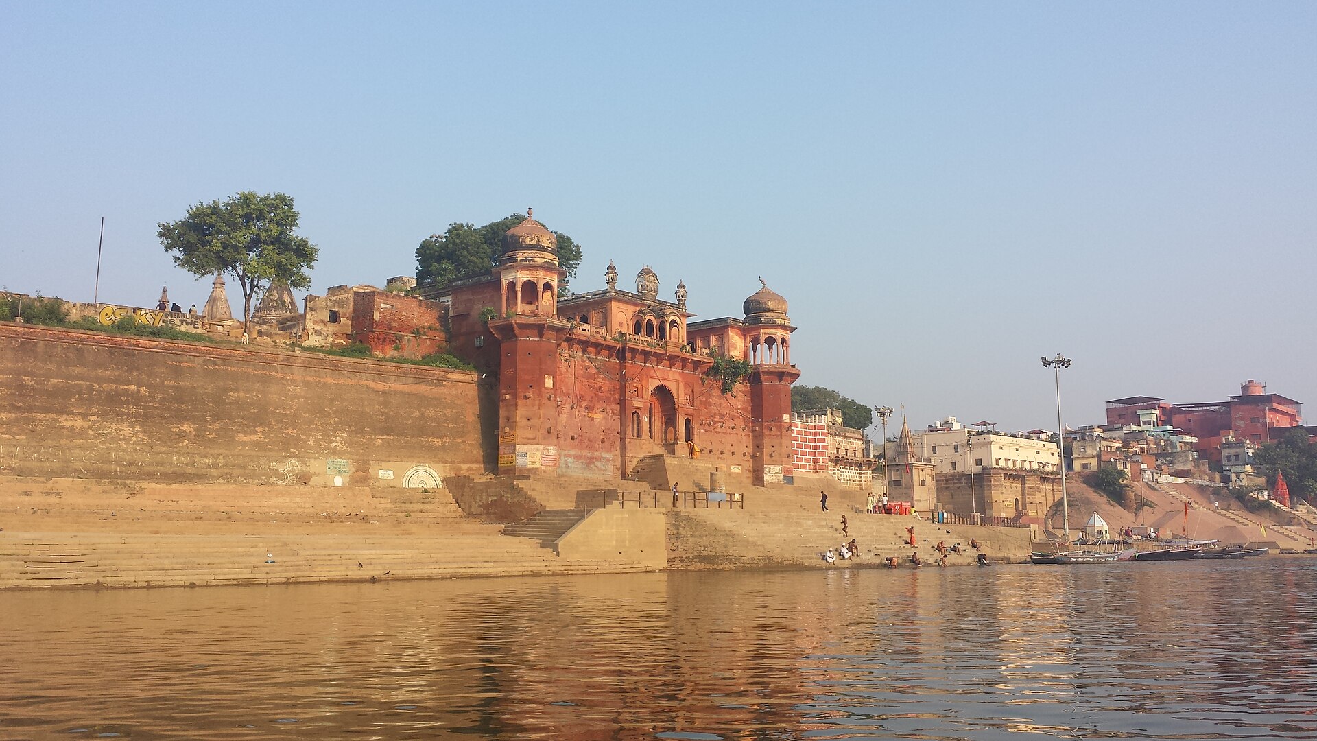 Chet Singh Ghat from the river: the red sandstone fort walls and domed pavilions above quiet steps
