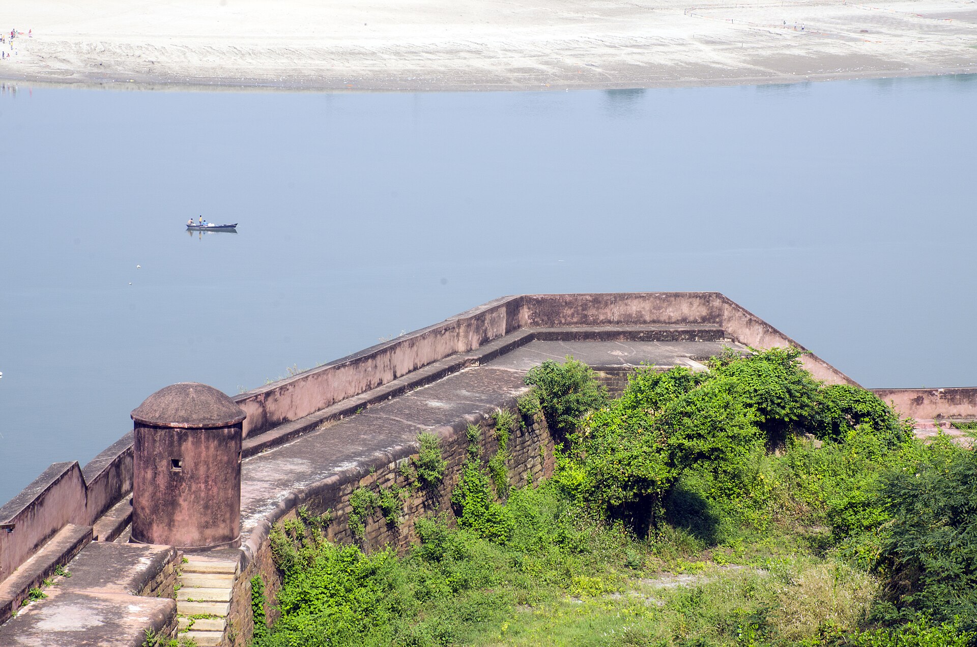 The ramparts of Chunar Fort high above the Ganga, a single boat on the water below